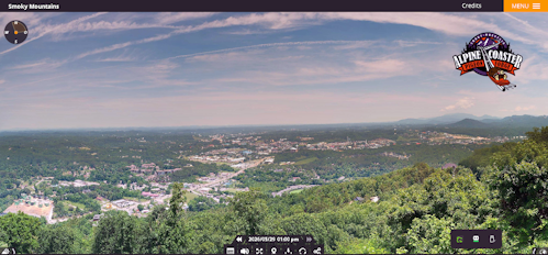 Panoramic view of the Smoky Mountains with a valley town below, overlaid by page UI elements and a logo in the top-right corner.